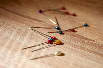 colored sewing needles on wooden background