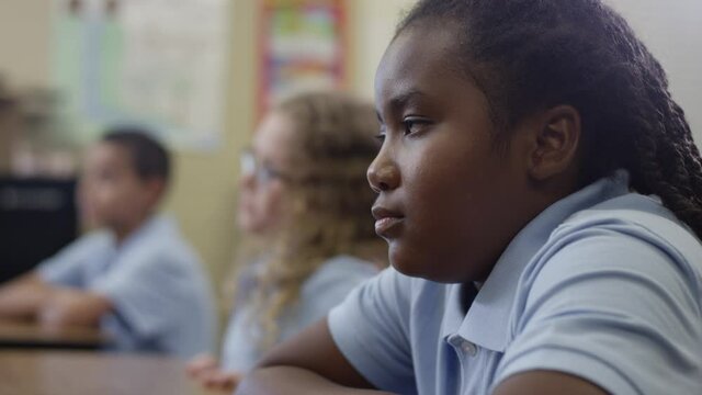Young black girl looks up at the teacher and sighs. Student with depression.
