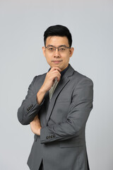 Portrait of Asian businessman happy smiling in grey confident suit. Isolated on grey background in studio.