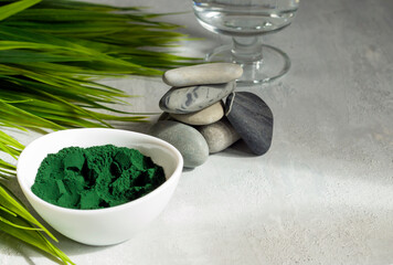 Spirulina powder on a light background. Healthy food supplement for vegan, vegetarian or plant based diets. SPA procedures.Contains multivitamins