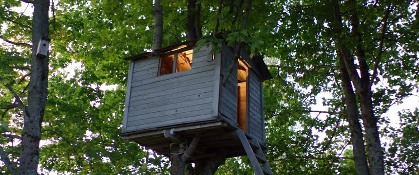 Light is turning on inside of a wooden handmade backyard tree house. Shot on RED cinema camera with 2x Anamorphic lens