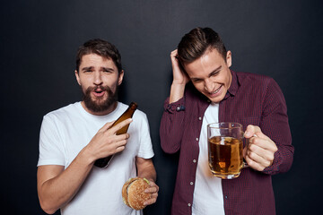 Two drunk friends drinking beer rest fun dark background