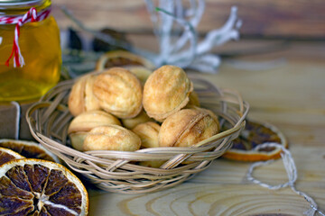 Handmade Christmas gifts. Cookies nuts, a jar of honey, dried oranges, a box with a gift, tapes for packaging on a wooden background. The concept of Christmas edible gifts.