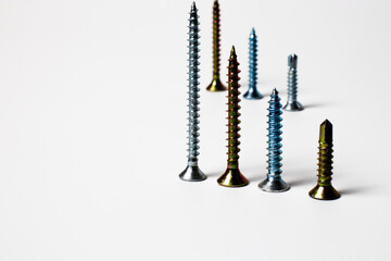 Art composition of colored screws. Four screws in focus , other three screws out of focus on background. Screw closeup