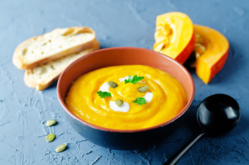 Pumpkin soup with pumpkin seeds and parsley leaves