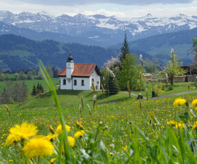 Little chapel on a medow with mountains in the background