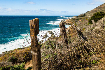 Rustic tangled barbed wire fence on the coast of Big Sur