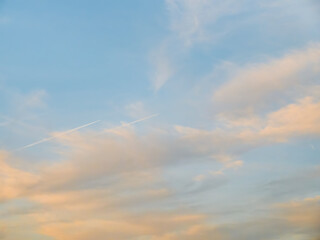 Contrail left by an airplane on a dramatic sky at sunset.