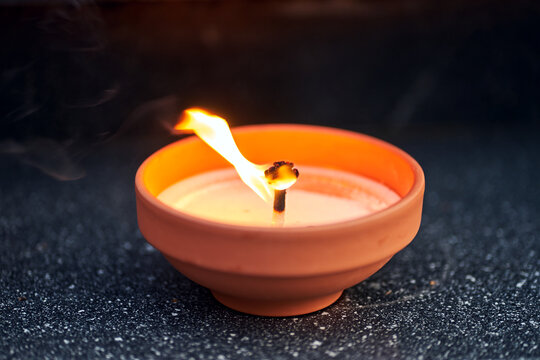 A candle burning on a grave in the cemetery of All Saints' Day