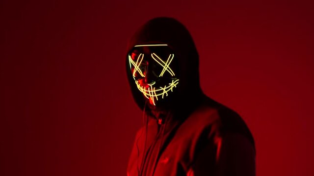 A man wearing a mask under fluorescent light. Unconventional Halloween masks