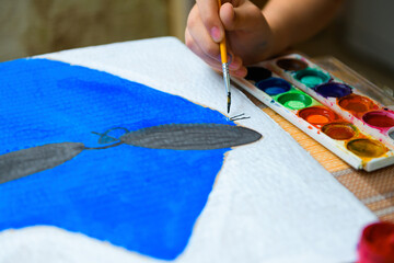 a girl drawing blue gouache cardboard, artistic creation at home, makes creative artwork