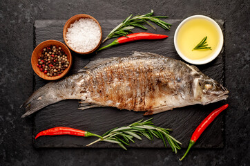 grilled sea bass fish with spices on a stone background
