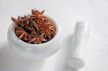 star anise in a mortar and pestle is ready to be crushed. Grinding of spices. Close up. Copy space