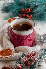 Hot winter tea in a red mug with candied oranges and a warm scarf - Christmas rural still life