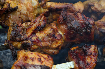 Chicken skewers on coals in the grill .