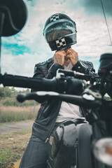 Motociclista hombre mexicano en carretera sobre su motocicleta con chaqueta de cuero y botas