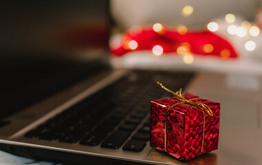 Christmas giftbox placed on laptop. Online shopping. Sale.