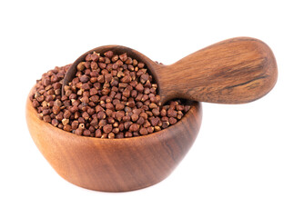 Guinea pepper grains in wooden bowl and spoon, isolated on white background. Melegeta, alligator pepper or mahlab. Grains of paradise.