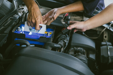 Engine engineer is replacing  car battery because car battery is depleted. concept car maintenance And the cost of car care.