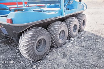 8x8 ATV all-terrain vehicle closeup view of aggressive wheels tread standing on sandy soil © EdNurg