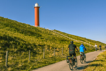 Cyclists and the 'Groote Kaap'; the lighthouse of Julianadorp, the Netherlands.