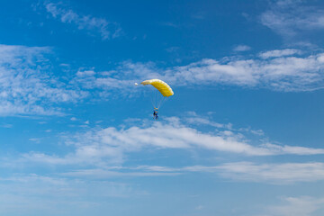 Parachutist is flying in the sky, sunny contrast image.