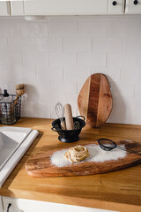 Fresh raw homemade pasta with flour and kitchen accessories on wooden counter. Healthy eating concept