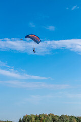 Parachutist is flying in the sky, sunny contrast image.