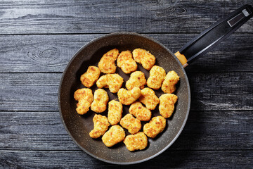 Chicken nuggets fried on a skillet, copy space