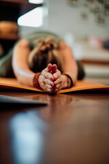 Closeup of woman in Wide Child's pose. Selective focus on hands.