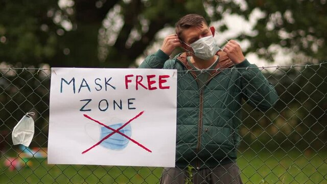 The area is free from wearing masks. Anti masks concept, covid skeptics and their protest. The poster on the fence. The young man hung the mask on the fence and left