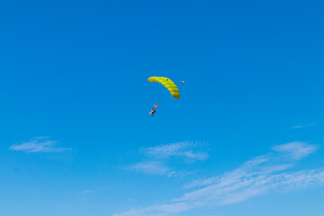 Naklejka na ściany i meble Parachutist is flying in the sky, sunny contrast image.