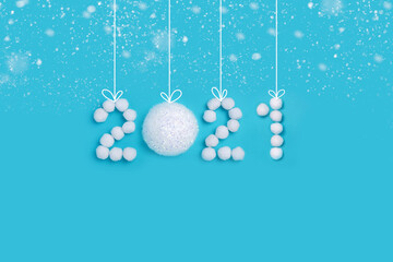 Fototapeta na wymiar 2021 New Years numbers made of white artificial snow and balls on a blue background