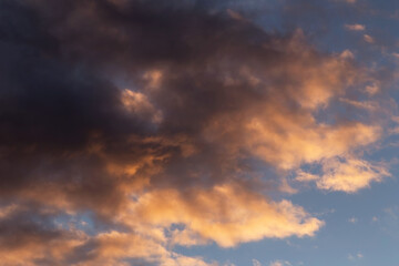 Fototapeta na wymiar Epic dramatic sunset, sunrise sky with dark storm clouds in orange yellow sunlight 