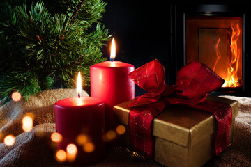 Christmas decorations with log fire
Christmas decorations with log fire and festive bokeh. Atmospheric christmas still life with candlelight and gift box on rustic linen sack. Space for your text. 
