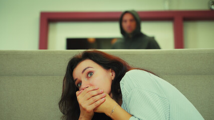 The girl hides in horror at home from a maniac with a knife.
