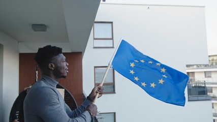 Young attractive black man waving European Union flag. High quality photo