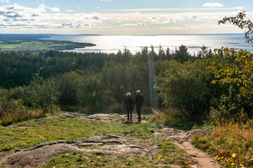 Senior couple walking down Omberg mountain with view of Lake Vättern
