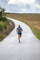 Obraz premium young man running on country road