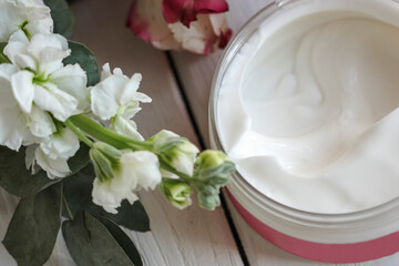 face cream, white, against flowers