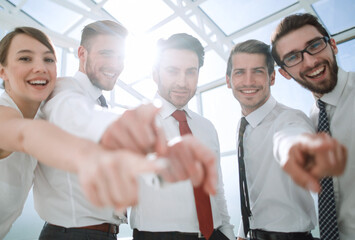 successful business team standing in the office and pointing at you