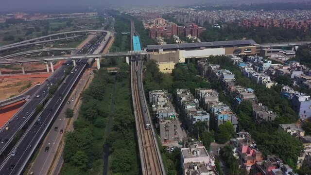An aerial shot of the Delhi metro leaving the station at Mayur Vihar, New Delhi, India