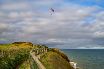 Paragliding over Sheringham cliffs and the seaside on the North Norfolk coast. Captured from the North Norfolk Coastal Path.