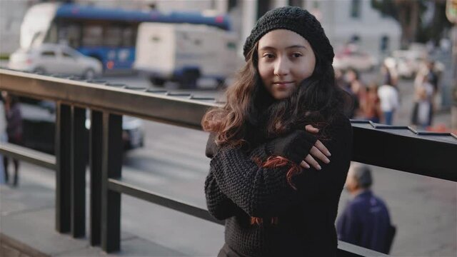 Vista de una adolescente por las calles de la Ciudad de M&eacute;xico con ropa de abrigo en una tarde de oto&ntilde;o, una ni&ntilde;a se frota porque tiene frio, imagen urbana con una ni&ntilde;a con el sol al frente