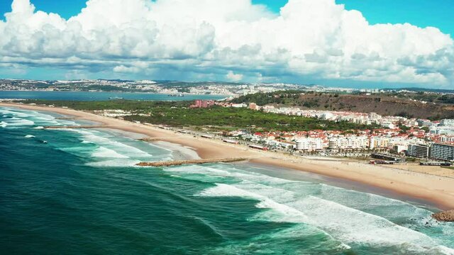 The Aerial footage of Costa da Caparica coastline of glorious sandy beaches, powerful Atlantic waves. Portugal