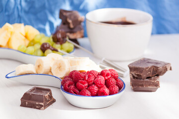 Fondue with melted chocolate, fruits and berries.