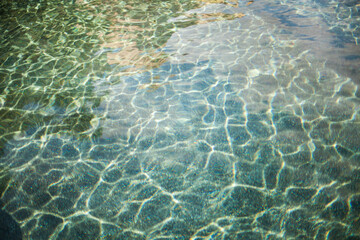 Light Captured in Aqua and Green Patterned Ripples on Swimming Pool Water