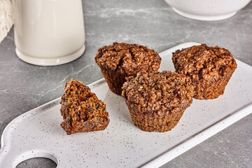 Healthy breakfast. Carrot vegan muffins and muesli or granola in white bowl on gray stone table. Kinfolk style.