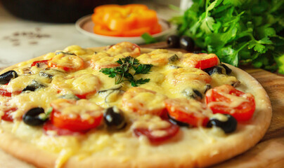 Homemade pizza with Servelat salami or pepperoni, tomatoes, mozzarella and Basil, edible, on a wooden table. Hot pepperoni pizza. Selective focus