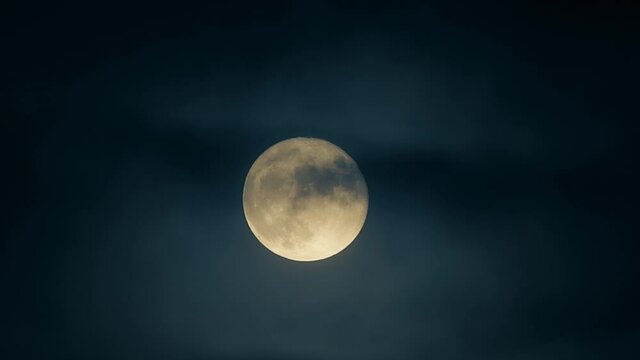 Closeup shot of a real life spooky full moon moving amongst a thin layer of fog